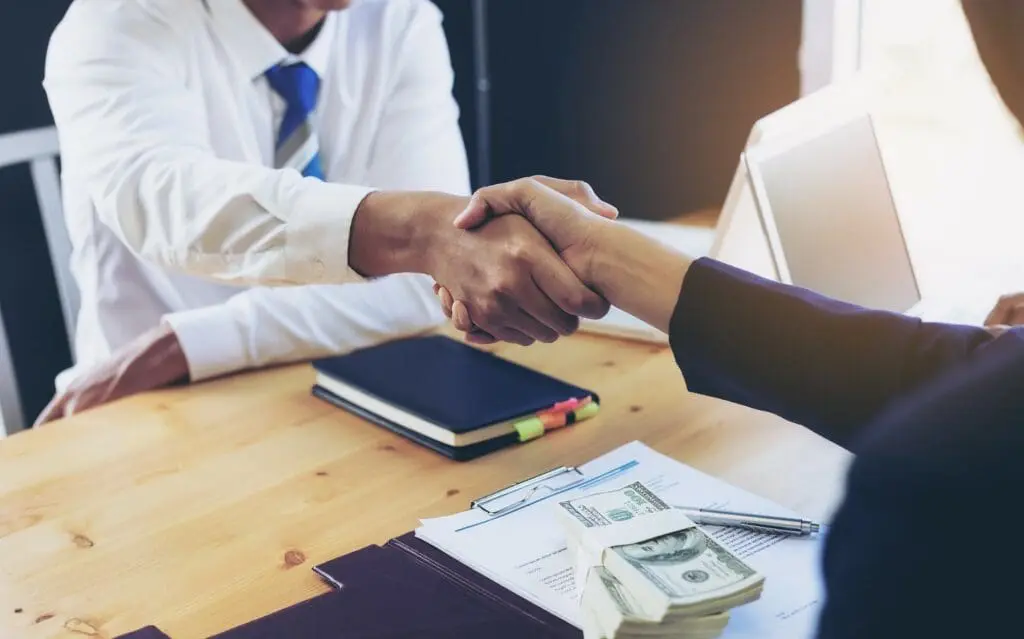 Hand shake and pleasant interaction shows reasons your business needs a collection agency.