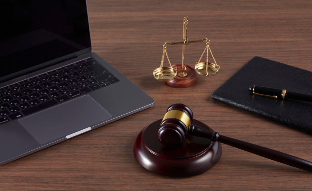 Laptop and gavel on desk, showing the decision between small claims court and hiring a collection agency.