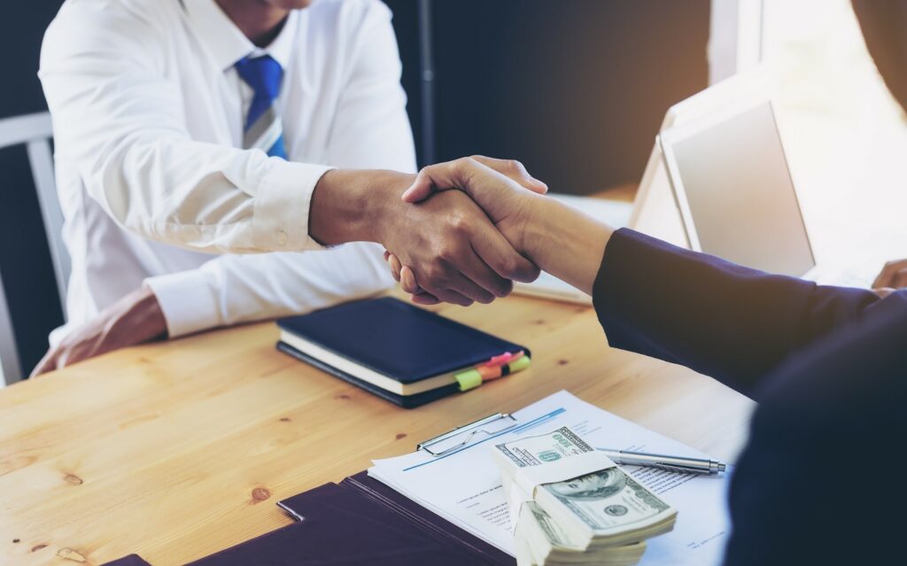 Hand shake and pleasant interaction shows reasons your business needs a collection agency.