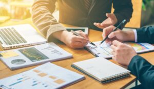 Office team examines reports while discussing what is a commercial collection agency and its financial impact
