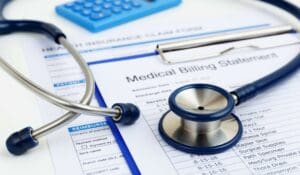 Stethoscope on a medical billing statement showing the importance of following medical debt collection laws.