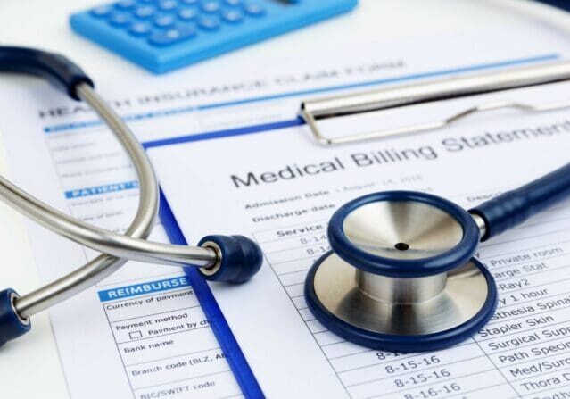 Stethoscope on a medical billing statement showing the importance of following medical debt collection laws.