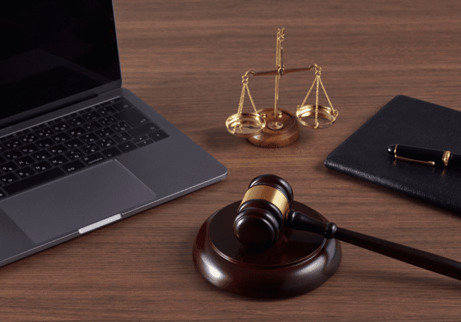 A laptop and a gavel on a desk, showing the choice between small claims court and hiring a collection agency.